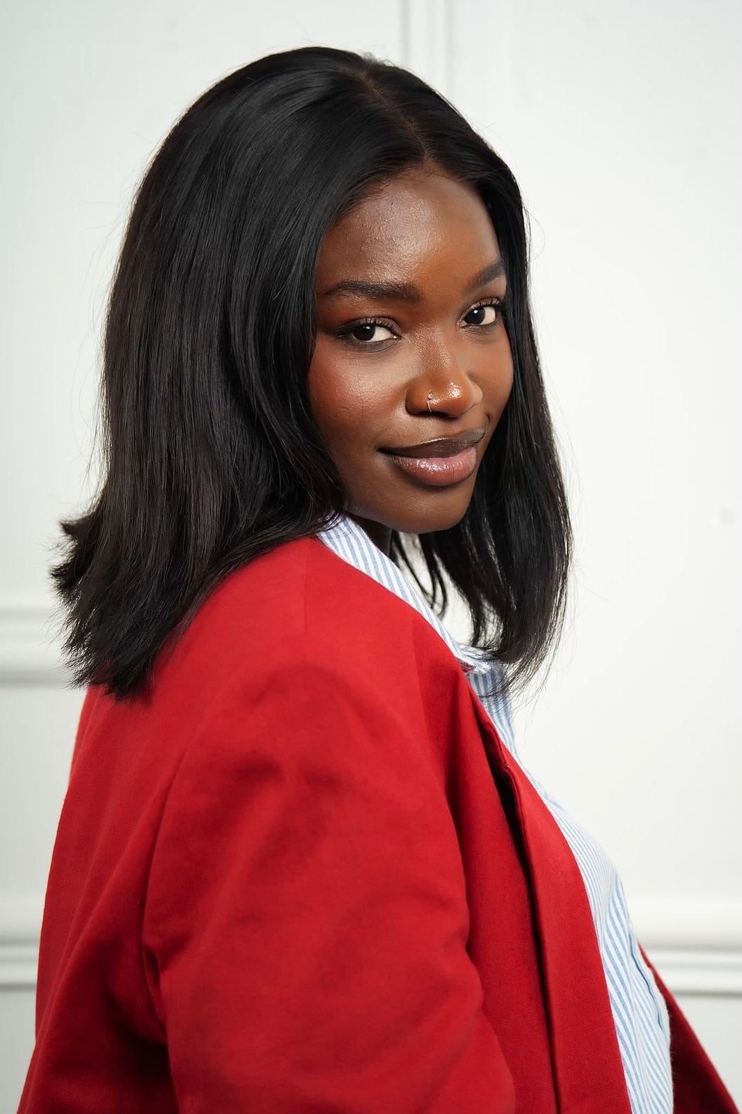 Personne en veste rouge, de trois quarts, regard vers l'objectif.